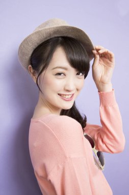 Yazlık şapkalı güzel Asyalı kadının stüdyo fotoğrafı. 