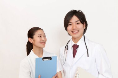 Asyalı tıp doktorları beyaz arka planda sırıtıyorlar.