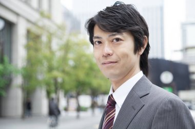 Asyalı işadamı kameraya bakıyor