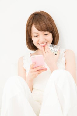 Evde cep telefonu kullanan güzel bir Japon kadın.