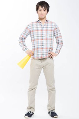 Asyalı bir adam megafon tutan bir gömlek giyiyor. 