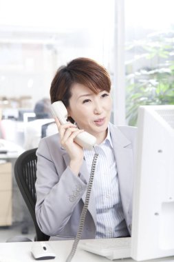 Ofiste Asyalı kadın konuşuyor.