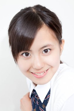 Okul üniformalı genç Japon kızın stüdyo portresi.