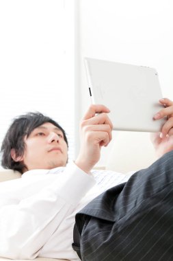 Tablet bilgisayar kanepede kullanarak iş adamı 