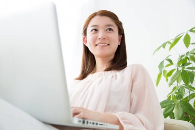 dizüstü bilgisayar kullanan genç iş kadını gülümseyen