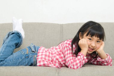 Kanepede yatan Asyalı küçük kız.