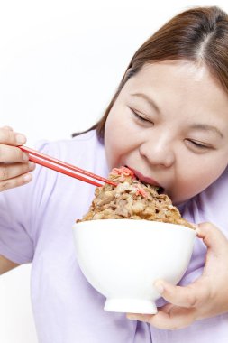 Şişman Asyalı kadın et yiyor. Stüdyo resmi