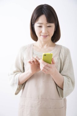 Mutlu genç Asyalı kadın cep telefonu kullanıyor.