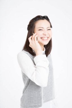 Akıllı telefondan konuşan güzel Japon kadının stüdyo portresi.