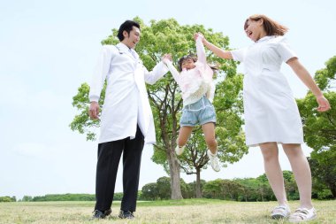 Parkta bir kızla birlikte Asyalı doktor ve hemşire  