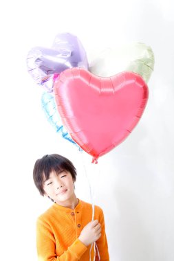 Kalp balonlu Asyalı çocuk, stüdyo fotoğrafı.
