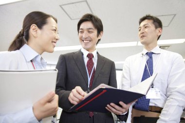 Bir grup genç Japon iş adamı projeyi tartışıyor. takım çalışması konsepti