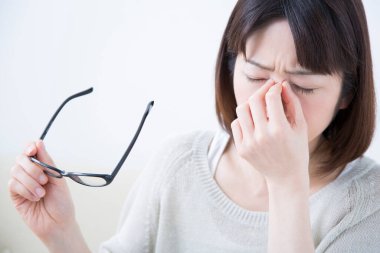 Baş ağrısı olan Asyalı genç bir iş kadını.