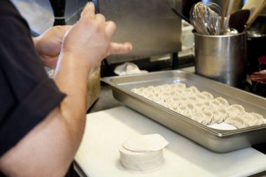 Şef ticari mutfağa çiğ hamur köftesi koyuyor.