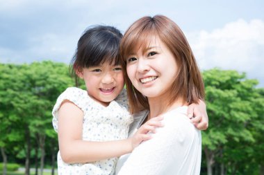 Anne ve kızı parkta gülümseyen