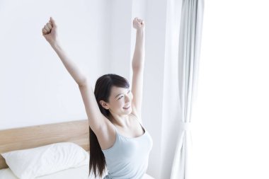 Genç Asyalı kadın sabahları geriniyor.