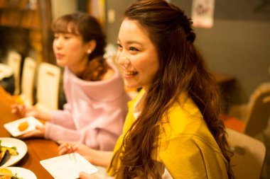 Genç kadınlar bir kafede yemek yiyorlar.