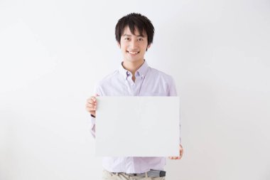 Beyaz tahta tutan Asyalı adam, stüdyo fotoğrafı. 