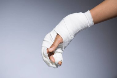 Gri arkaplanda kadın el bandajı, yakın görüş.