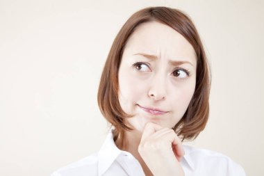 Eli çenesinde düşünen genç bir kadının portresi.