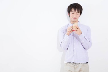 Beyaz arka planda akıllı telefonu olan genç Asyalı iş adamı