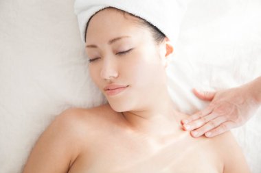 Güzel Asyalı kadın güzellik salonunda masaj yaptırıyor.