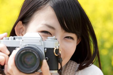 Kadın kamerayla fotoğraf çekiyor.