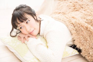 Genç bir kadın oturma odasında dinleniyor. 