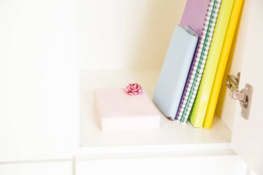 Dolabında hediye olan renkli defterler.