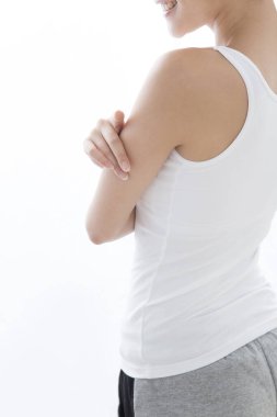 Genç Asyalı kadın koluna dokunuyor, stüdyo çekimi. 