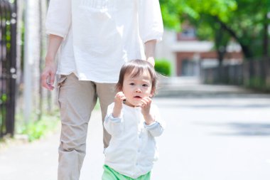 Anne ve oğlu parkta yürüyor.