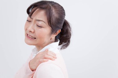 Güzel, olgun bir Japon kadının portresi açık arka planda acıdan muzdarip