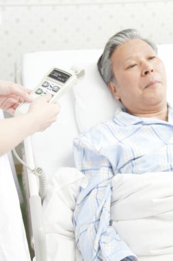 Hastane yatağında yatan adam tedavi görüyor.