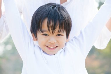 Genç Asyalı kadın oğluyla birlikte parkta.