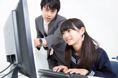 Masada bilgisayar kullanan bir kıza yardım eden adam.