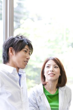 Kadın ve erkek pencerenin yanında konuşuyor.