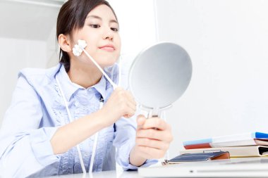 young woman with mirror using massager  clipart