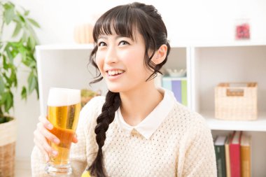 Arka planda bira içen Asyalı kadın