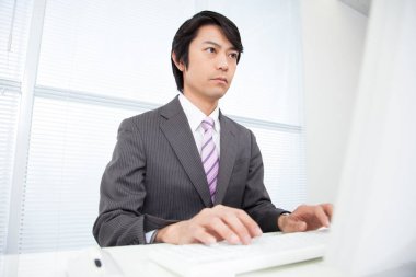 Ofiste çalışan kendinden emin genç Japon işadamı.