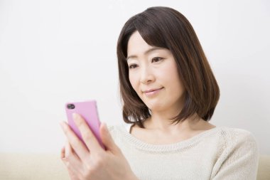 Evde cep telefonu kullanan bir kadın