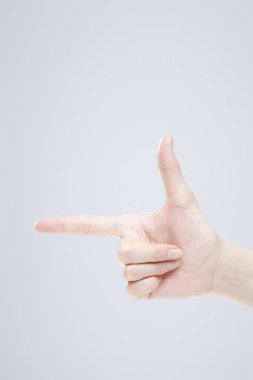 Beyaz arka planda el hareketi yapan kadınların yakın çekimi. 