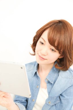 Dijital tablet kullanan gülümseyen Asyalı kadın