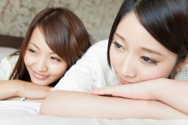 İki kadın yatakta dinleniyor.