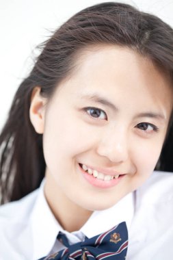 Okul üniformalı genç Japon kızın stüdyo portresi.