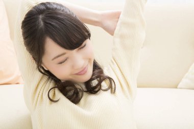 Asyalı iş kadını kanepede dinleniyor. 