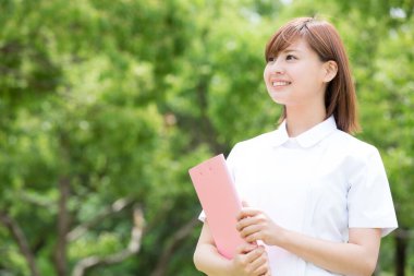 Park yerinde panosu olan genç bir üniversite öğrencisi.