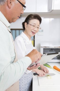 Asyalı kıdemli eş kocasına yemek hazırlıyor..