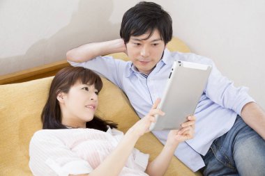 Erkek arkadaşıyla tablet bilgisayar kullanan bir kadın.