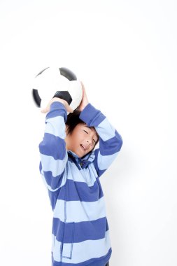 Futbol topu taşıyan Asyalı bir çocuğun portresi. 