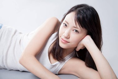 Genç bayan yatak odasındaki kanepede yatıyor.